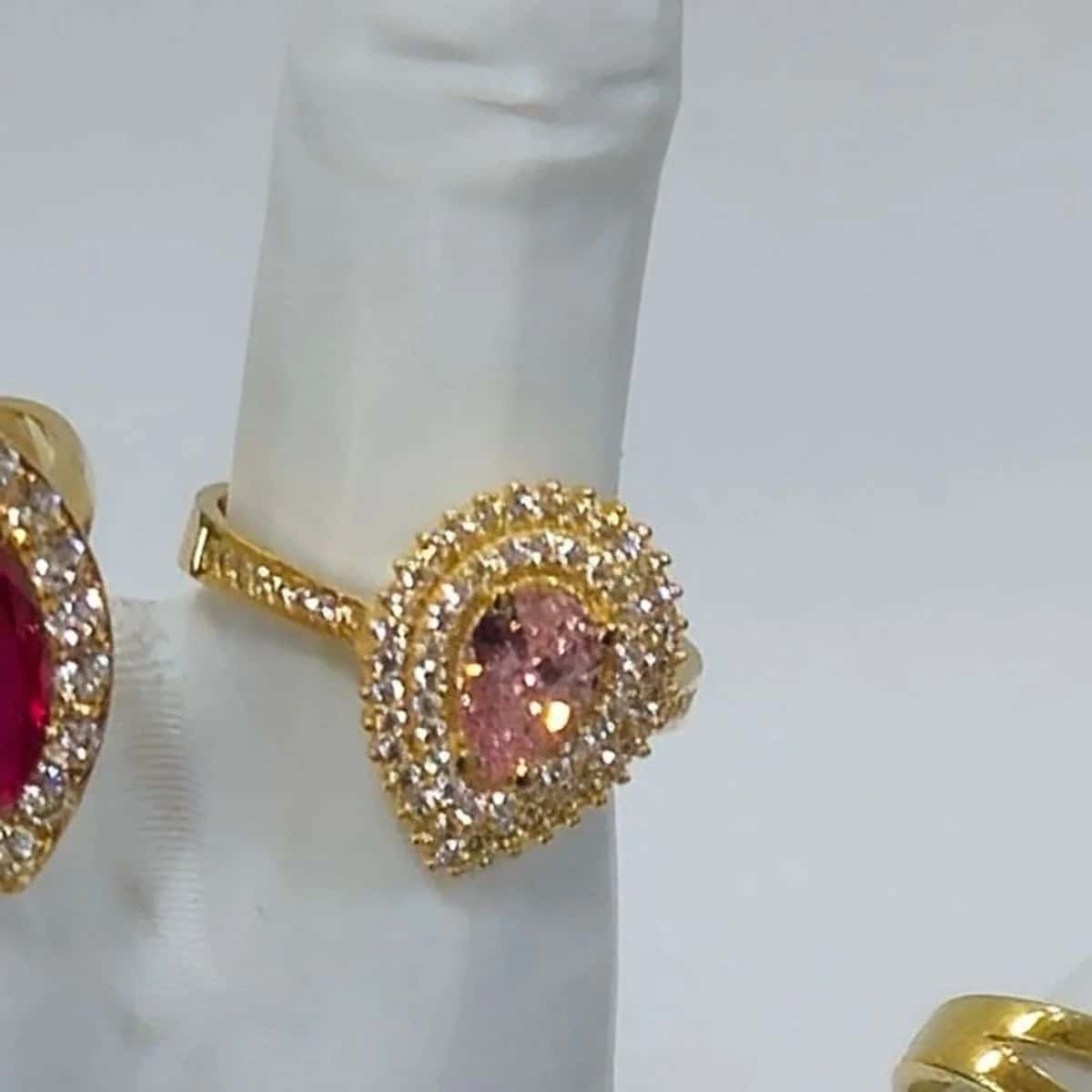 Pembe damla taşlı, çevresi beyaz taşlı altın yüzük.
